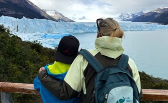 Eine Frau und ein Kind stehen am Geländer und betrachten den beeindruckenden Perito-Moreno-Gletscher in Patagonien.