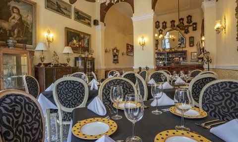 Elegante Restaurant mit kunstvollen Gemälden, stilvollen Tischen und einer einladenden Atmosphäre für ein feines Essen.