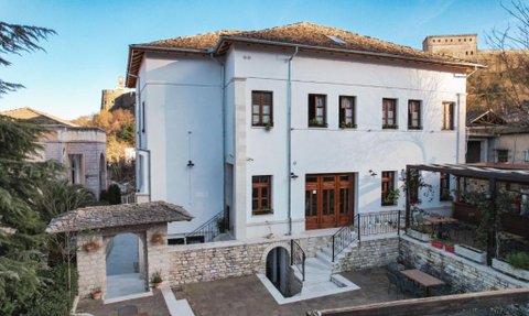 Das elegante Hotel Bineri in Gjirokaster zeigt eine moderne Fassade mit Holzfenstern und einem einladenden Eingangsbereich.