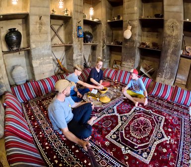 Familie sitzt auf dem Boden im Bait al Safah Museum in Al Hamra – Oman mit Kindern