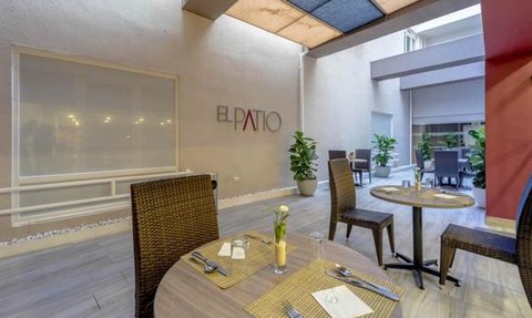 Ein eleganter Essbereich mit einem Tisch, dekoriert mit einer Blume, umgeben von Pflanzen und einem modernen Ambiente.