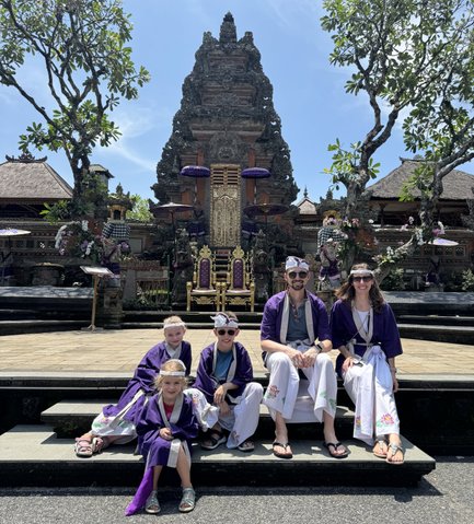Familie in balinesischer Kleidung besucht den Pura Taman Saraswati Tempel – Bali mit Kindern