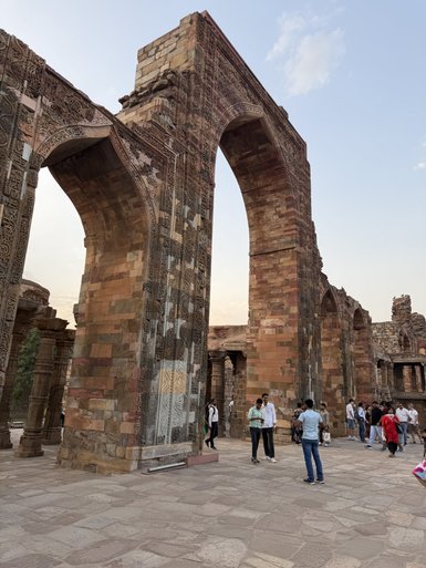 Die beeindruckenden, kunstvoll verzierten Bögen des Qutub Minar ziehen zahlreiche Besucher an, die die Architektur bewundern.