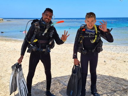 Kind und Guide mit Tauchequipment am Roten Meer - Familienreise nach Ägpyten