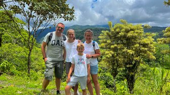 Familie lächelt und posiert im grünen Dschungel – Costa Rica mit Kindern