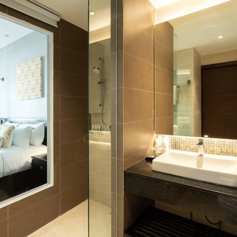 Ein modernes Badezimmer mit einer eleganten Dusche und einem stilvollen Waschbecken, das in sanften Erdtönen gehalten ist.