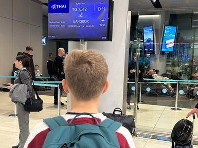 Teenager wartet am Gate auf seinen Abflug nach Bangkok – Thailand Reise mit Kindern