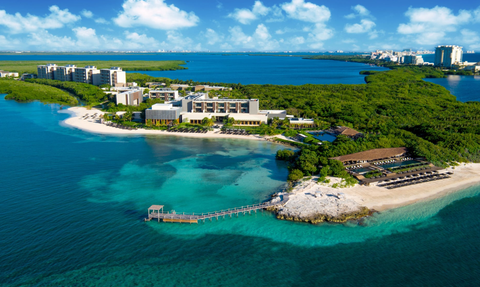Ein luxuriöses Resort am Wasser, umgeben von üppigem Grün und klarem, türkisfarbenem Wasser, ideal für Entspannung.