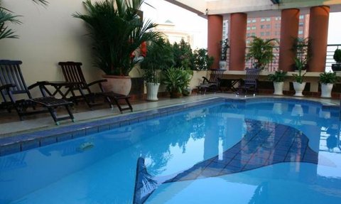 Ein einladender Pool umgeben von üppigen Pflanzen und gemütlichen Liegen, ideal für Entspannung und Erholung.