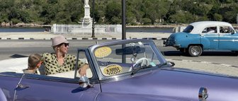 Bunte Oldtimer auf der Straße vor malerischer Kulisse - Kuba mit Kindern