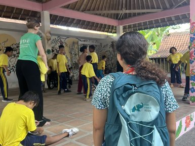 Ein Mädchen trägt einen FFR-Rucksack bei Yayasan Widya Guna – Bali Familienreise