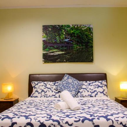 Ein komfortables Schlafzimmer mit einem gemütlichen Bett, dekoriert mit blauer Bettwäsche und einem großen Kissen.
