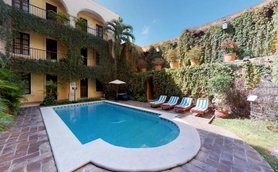 Ein einladender Pool umgeben von üppigem Grün und blühenden Pflanzen, ideal für entspannende Momente im Freien.