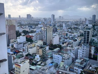 Ein Blick auf die Stadt Da Nang, mit vielen Gebäuden und einem bewölkten Himmel, der eine ruhige Atmosphäre schafft.
