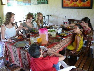 Familie sitzt zusammen beim Essen und teilt fröhliche Momente – Nicaragua Reise mit Kindern