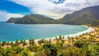 Ein atemberaubender Blick auf die Küste von Maracas Bay, umgeben von üppigen Bergen und klarem, blauem Wasser.