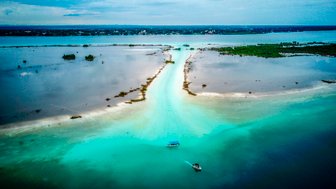 Türkisblaue Lagune von Bacalar mit mehreren Booten aus der Vogelperspektive – Mexiko Reise mit Kindern