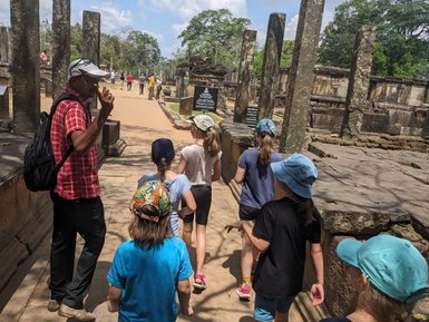 Kinder lauschen einem Guide bei den historischen Ruinen von Polonnaruwa – Sri Lanka Familienreise