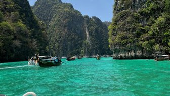Phuket Bootsfahrt bei blauen Himmel und klarem Wasser mit mehreren Booten - Thailand Familienreise