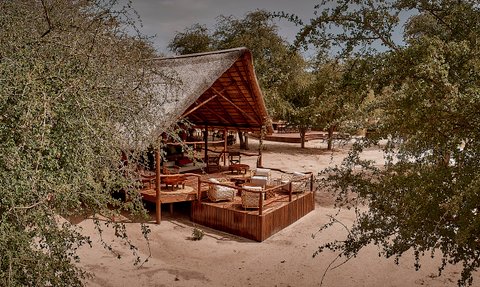 Ein rustikales Lodge-Gebäude in der Deception Valley, umgeben von üppigem Grün und einem einladenden Holzdeck.