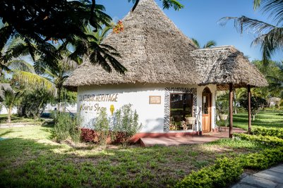 Die Außenansicht eines kleinen Bungalows mit Strohdach im Karafuu Beach Resort 
