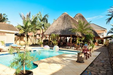 Ein einladender Poolbereich mit Palmen und einem Strohdach, ideal für Entspannung und Erholung unter der Sonne.