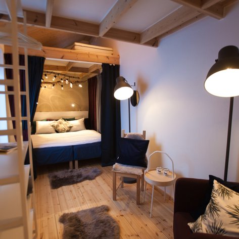 Ein gemütliches Zimmer mit einem Doppelbett, umgeben von warmen Lichtern und einem modernen, einladenden Ambiente.