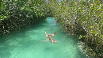 Kinder schwimmen lachend im natürlichen Wasserkanal des Naturreservats Sian Ka’an – Mexiko Familienreise