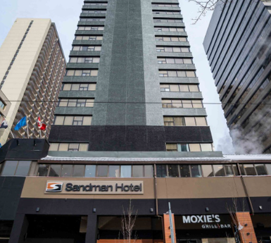Das Sandman Hotel in Calgary erhebt sich majestätisch zwischen modernen Wolkenkratzern und bietet eine einladende Fassade.