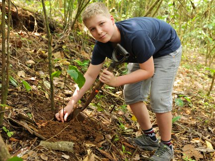 Junge beim Baum Pflanzen in Costa Rica – Costa Rica Familienreise