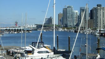 Ein Blick auf den Hafen von Vancouver mit vielen Booten und modernen Wolkenkratzern im Hintergrund unter klarem Himmel.