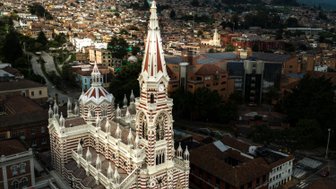 Die beeindruckende Kathedrale mit rot-weißen Streifen erhebt sich majestätisch über die Stadt Bogotá und die umliegenden Berge.