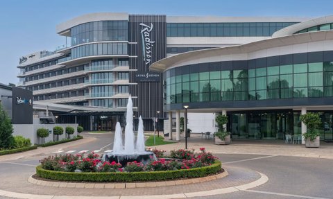 Das Radisson Hotel in Johannesburg zeigt eine moderne Architektur mit großen Fenstern und einem eleganten Eingangsbereich.