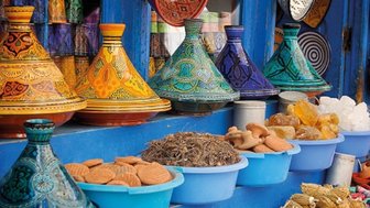 Tajine-Töpfe in verschiedenen Farben und Formen auf einem Marktstand in Marrakesch – Marokko mit Kindern