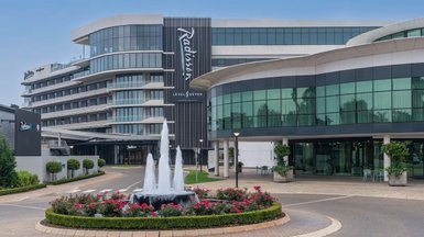 Das Radisson Hotel in Johannesburg zeigt eine moderne Architektur mit großen Fenstern und einem eleganten Eingangsbereich.