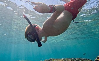 Kind schnorchelt unter Wasser an den Daymaniyat Inseln – Oman mit Kindern