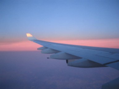 Blick aus dem Flugzeugfenster auf den strahlenden Sonnenaufgang – Südafrika Reise mit Kindern