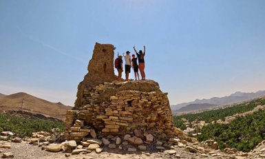 Familie steht oben auf einem Felsenhaus im Dorf Birkat Al Mauz – Oman mit Kindern