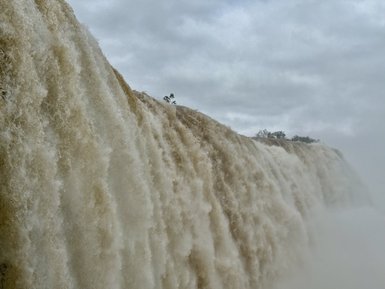 Die Iguaçu-Wasserfälle stürzen majestätisch in die Tiefe, während ein feiner Nebel die Szenerie umgibt.