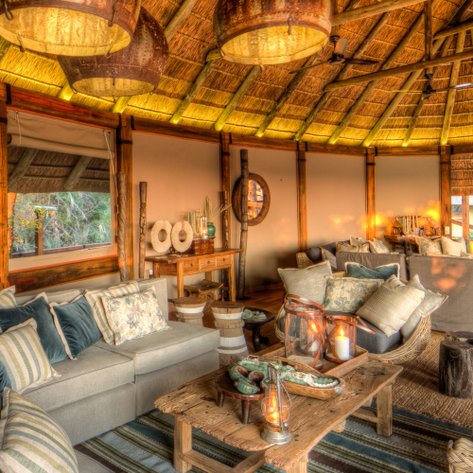 Ein gemütlicher Wohnbereich in einer Lodge, ausgestattet mit bequemen Sofas und warmem Licht, das eine einladende Atmosphäre schafft.