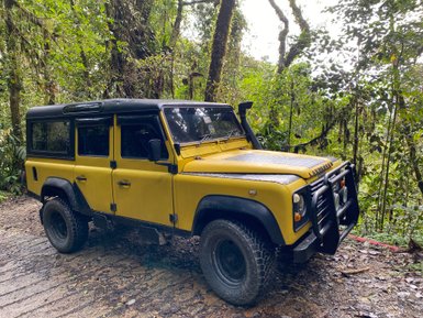 Land Rover steht vor der grünen Hügellandschaft der Cameron Highlands – Malaysia & Borneo Familienreise