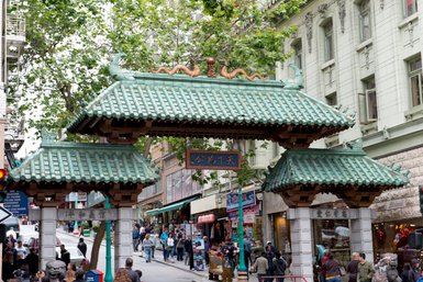 Ein Bogen mit traditionellen Verzierungen wurde über eine Straße gebaut und zeigt den Eingang in den Bereich Chinatown 