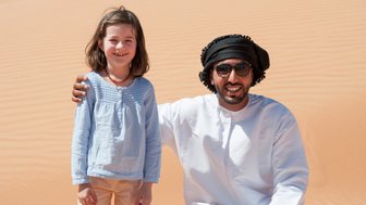 Mädchen trifft einen Beduinen in der Weite der Wahiba Sands – Oman Familienreise