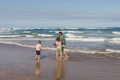 Mutter mit Kindern genießen den Strand am Wilderness Beach – Südafrika mit Kindern
