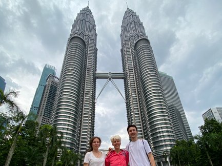 Mutter posiert mit Kindern vor den Petronas Twin Towers in Kuala Lumpur – Malaysia & Borneo Familienreise