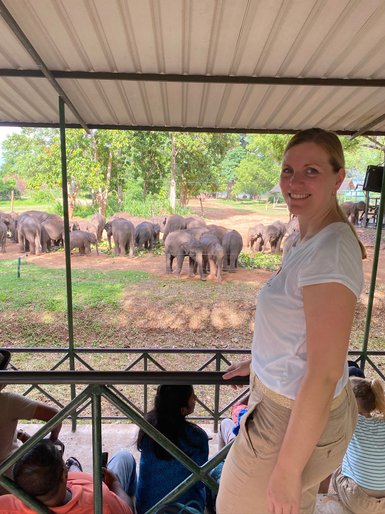 Frau steht vor dem Gehege mit Elefanten im Elephant Transit Home im Udawalawe Nationalpark – Sri Lanka mit Kindern