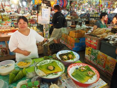 lokaler Essensstand mit froehlicher Einheimischen Verkaeuferin auf Chiang Mai Markt - Thailand Reise mit Kindern 