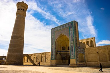 Die beeindruckende Mir-i-Arab-Madrasa in Buchara, mit ihrem hohen Minarett und kunstvollen Mosaiken, strahlt historische Pracht aus.