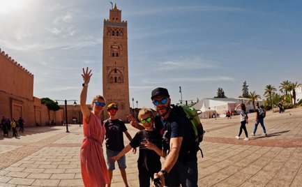 Familie hält den Moment vor der berühmten Koutoubia in Marrakesch mit einem Selfie fest – Marokko mit Kindern