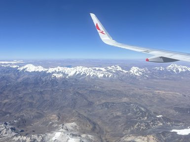 Der Blick aus dem Flugzeug zeigt die schneebedeckten Gipfel der Anden unter einem strahlend blauen Himmel.